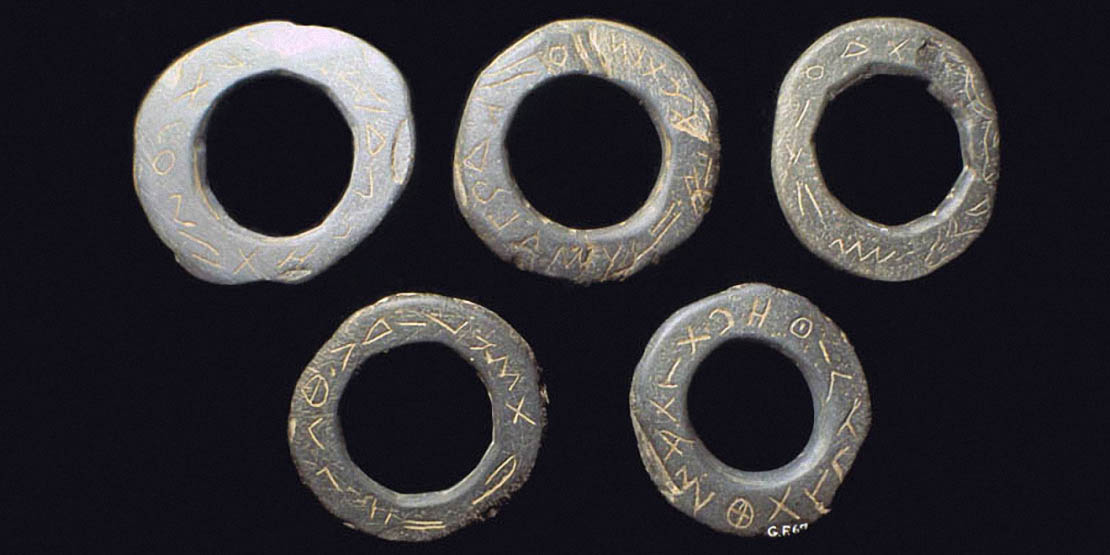 Cinq anneaux de schiste inscrits de signes alphabétiformes