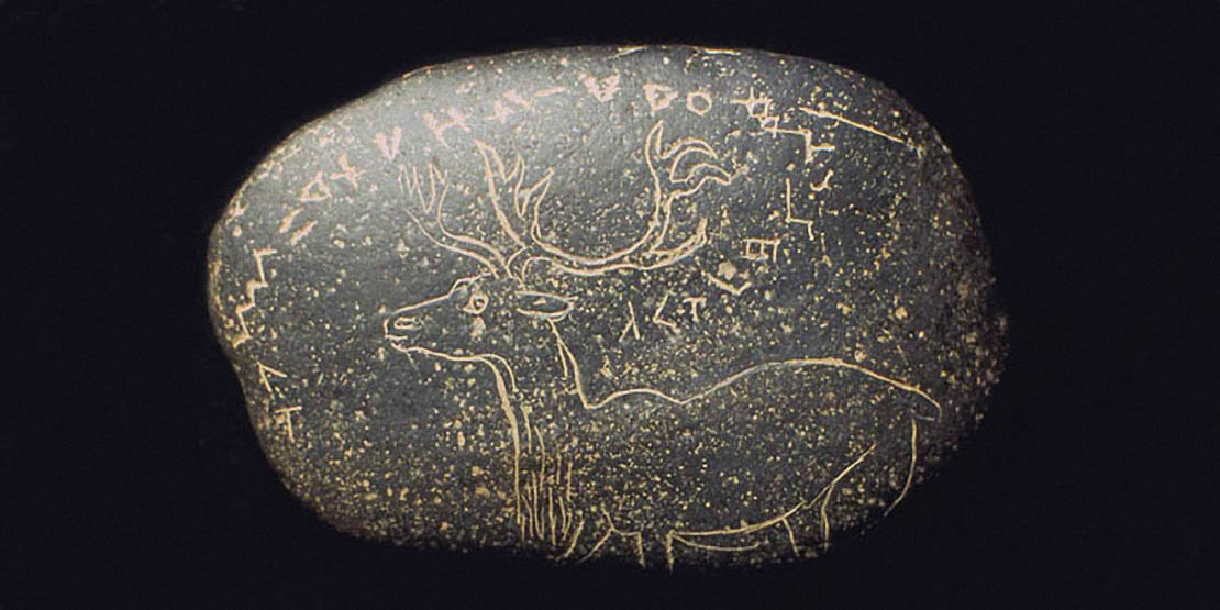 Galet  gravé d’un renne (?) surmonté d’une inscription alphabétiforme